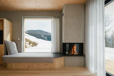 a bed in a room with a fireplace and a window at Chalet Herol in Luson