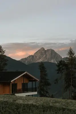 a house on a hill with a mountain in the background at Chalet Herol in Luson