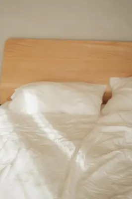 an unmade bed with white sheets and pillows at Chalet Herol in Luson