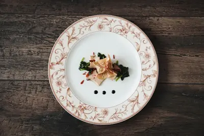 a plate of food on a wooden table at Alpenpalais Kröll in Schenna