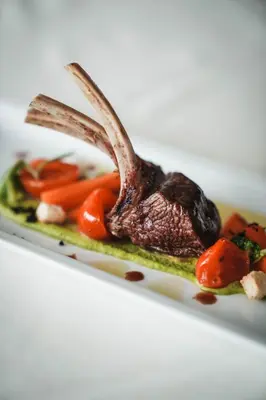 a plate of food with a rabbit on top of vegetables at Alpenpalais Kröll in Schenna