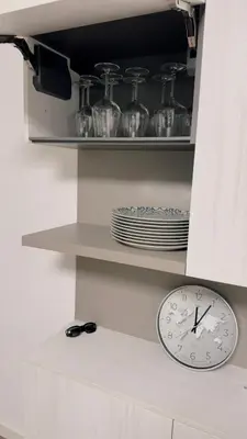 a clock on a shelf with plates and glasses at Appartment Alleghe center in Alleghe