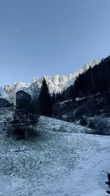 a snow covered field with a mountain in the background at Appartment Alleghe center in Alleghe