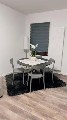 a table and chairs with a vase of flowers on it at Appartment Alleghe center in Alleghe