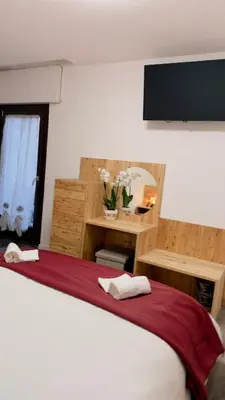 a bedroom with a bed with a red and white blanket at Appartment Alleghe center in Alleghe