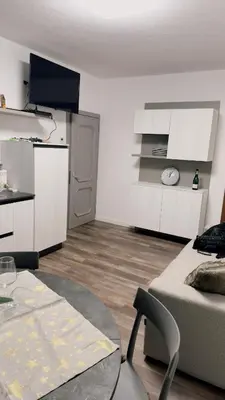 a living room with a couch and a table and a kitchen at Appartment Alleghe center in Alleghe