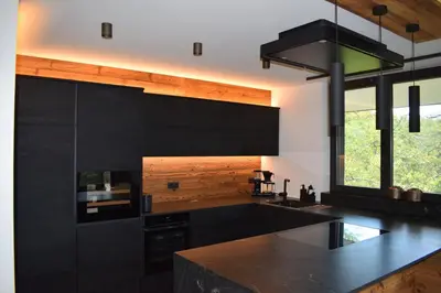 a kitchen with black cabinets and a black counter top at FeWo Passo-Palade in Tesimo
