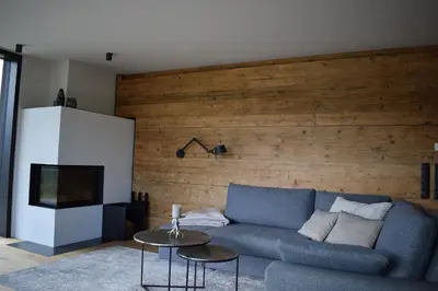 a living room with a blue couch and a television at FeWo Passo-Palade in Tesimo