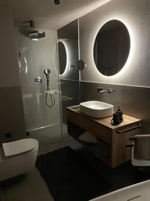 a bathroom with a sink and a toilet and a mirror at FeWo Passo-Palade in Tesimo