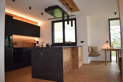 a kitchen with black cabinets and a black counter top at FeWo Passo-Palade in Tesimo