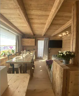 a dining room with a table and a table and a television at Luxury apartment in Cortina in Cortina dʼAmpezzo