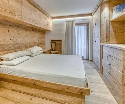 a bedroom with a large bed in a wooden room at Luxury apartment in Cortina in Cortina dʼAmpezzo