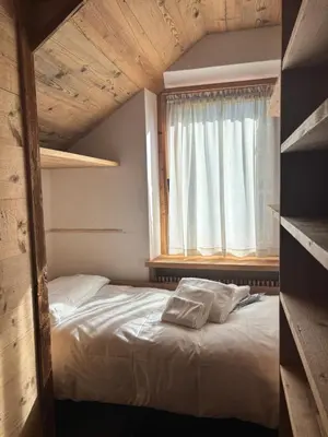 a bed in a room with a window and a bed sidx sidx sidx at Luxury apartment in Cortina in Cortina dʼAmpezzo