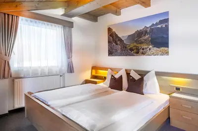 a bedroom with a large bed in a room at La Majon Apartments in Selva di Val Gardena