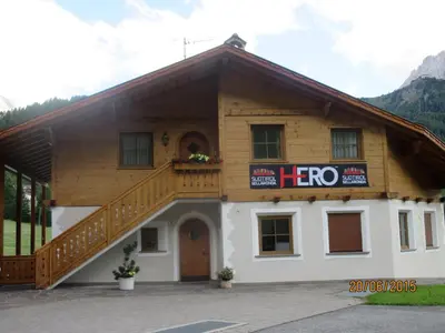 a building with a staircase on the side of it at La Majon Apartments in Selva di Val Gardena