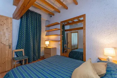 a bedroom with a blue bed and a mirror at Principe Marmolada 816 A in Malga Ciapela