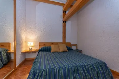 a bedroom with a bed and a table with a lamp at Principe Marmolada 816 A in Malga Ciapela