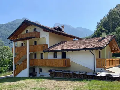a kitchen with a table and chairs and a refrigerator at Le porte dell'agordino in Zenich
