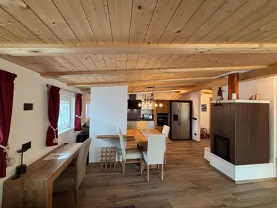 a kitchen and dining room with a wooden ceiling at Appartamento Cima 12 in Pozza di Fassa
