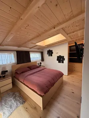 a bedroom with a large bed in a house at Appartamento Cima 12 in Pozza di Fassa