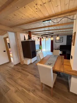 a dining room and living room with a table and chairs at Appartamento Cima 12 in Pozza di Fassa