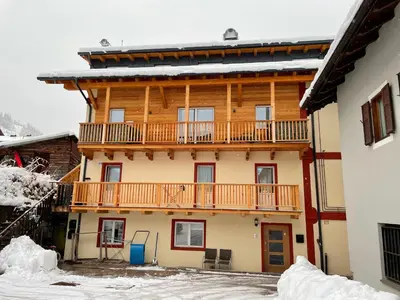 a large wooden building with a balcony on it at Appartamento Cima 12 in Pozza di Fassa