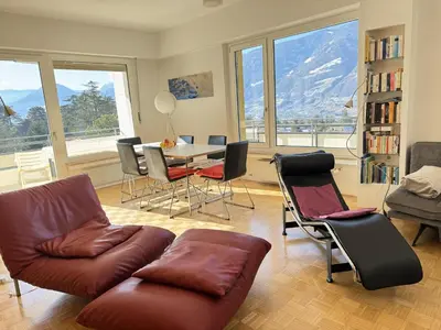 a living room with a couch and a table and chairs at MERANEA- sonnig - ruhig - elegant - ideal zum länger bleiben - Glasfaser in Merano