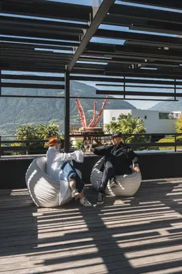 two people sitting in bean chairs on a building at Hotel Gartner in Tirolo