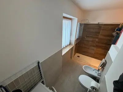 a bathroom with two toilets and a shower at Marmolada Escape in Malga Ciapela
