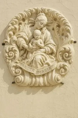 a statue of a woman holding a baby on a wall at VILLAREJA - Private City Suite im Herzen der Bozner Altstadt in Bolzano