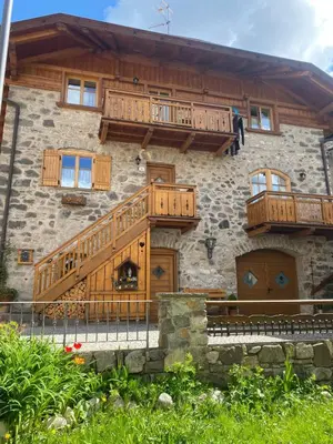 a house with wooden balconies on the side of it at tabià piz meda in Moena
