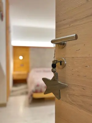 a door with a star attached to a room with a bed at tabià piz meda in Moena