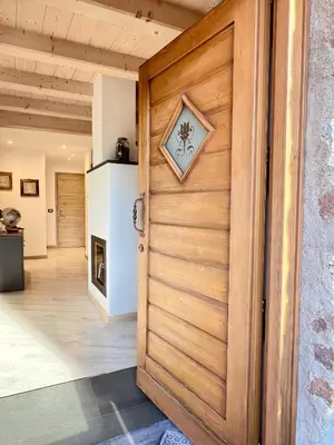 a wooden door in a kitchen with a refrigerator at tabià piz meda in Moena