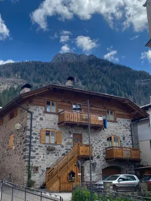 a building with wooden balconies on the side of it at tabià piz meda in Moena