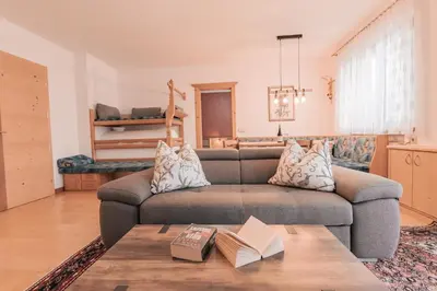 a living room with a couch and a table at Ladin Apartment in Antermoia