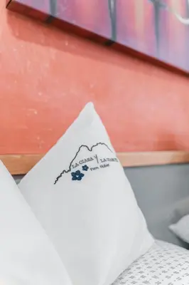a pillow with a drawing of a mountain on it at Ladin Apartment in Antermoia