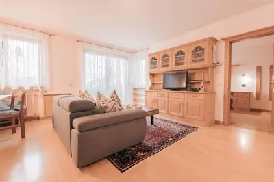 a living room with a couch and a tv at Ladin Apartment in Antermoia