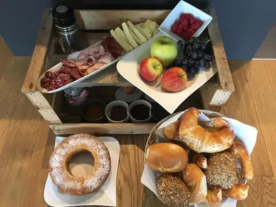 a wooden tray with different types of pastries and fruit at Wiesenheim- Schlernblick in Penone