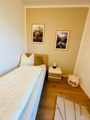 a bedroom with a bed and two pictures on the wall at Wiesenheim-Dolomitenblick in Penone
