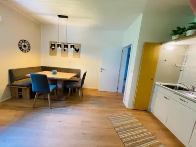 a kitchen and dining room with a table and chairs at Wiesenheim-Dolomitenblick in Penone