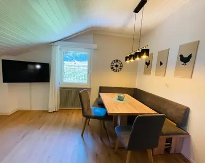 a dining room with a table and a couch at Wiesenheim-Dolomitenblick in Penone