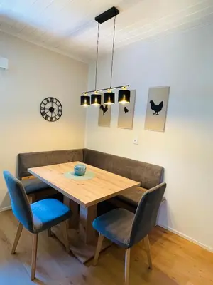 a dining room with a wooden table and chairs at Wiesenheim-Dolomitenblick in Penone