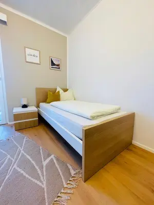 a bedroom with a bed with a wooden headboard at Wiesenheim-Dolomitenblick in Penone