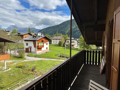 a balcony of a house with a view of a village at Mansarda nelle dolomiti in Falcade