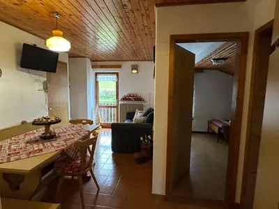a living room with a table and a couch at Mansarda nelle dolomiti in Falcade
