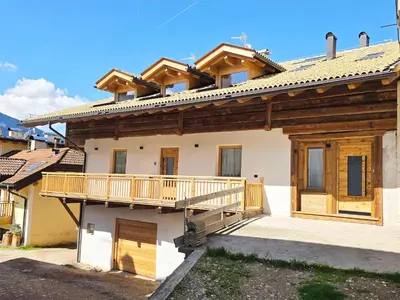 a house with a deck on the side of it at Alpine Lodge Tesero - Alpine Stay Apartments in Tesero