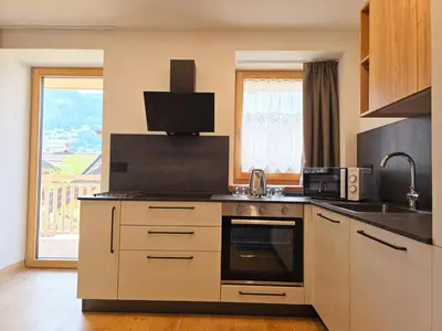 a kitchen with a sink and a stove top oven at Alpine Lodge Tesero - Alpine Stay Apartments in Tesero