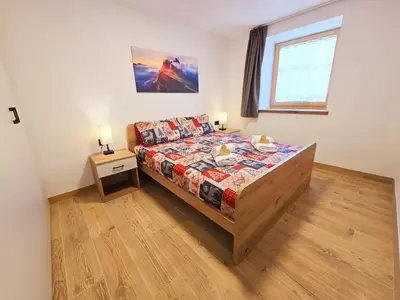 a bedroom with a bed and a window at Alpine Lodge Tesero - Alpine Stay Apartments in Tesero