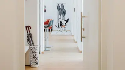 a hallway with white walls and wood floors at Rooftop Apartment - Alpstay in Naturno