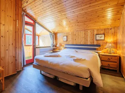 a bedroom with a large bed in a wooden room at Apartment Boiserie by Interhome in Campitello di Fassa